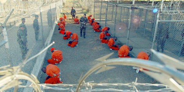 Detainees in the Guantánamo Bay Prison sit in a holding area at Camp X-Ray on January 11, 2002. Photo: Reuters/Shane T. McCoy