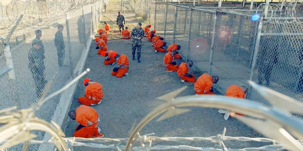 Detainees in the Guantánamo Bay Prison sit in a holding area at Camp X-Ray on January 11, 2002. Photo: Reuters/Shane T. McCoy