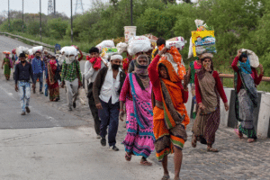 Migrant workers in New Delhi, India, walking through the highways to return to their villages in Uttar Pradesh, after country-wide lockdown was declared in late March 2020. Millions of such workers, who are rural migrants to urban centers, were forced to walk hundreds of kilometers as a nation of 1.37 billion people was closed down on a four-hour notice. Photo: Danish Siddiqui / Reuters