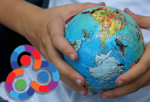 Kid holding a small ball with the South American map and the Antartida. Composition with Orinoco Tribune logo.