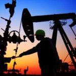 Oil workers in an oil field at sunset. File photo.