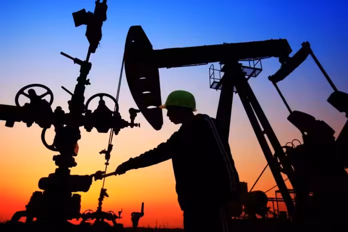 Oil workers in an oil field at sunset. File photo.