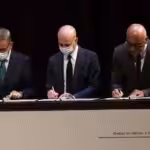 Jorge Rodríguez representing the Venezuelan government, Gerardo Blyde representing the opposition, and the representative from the Kingdom of Norway, all signing the document that officially launched the Mexico Talks in 2021. File photo.