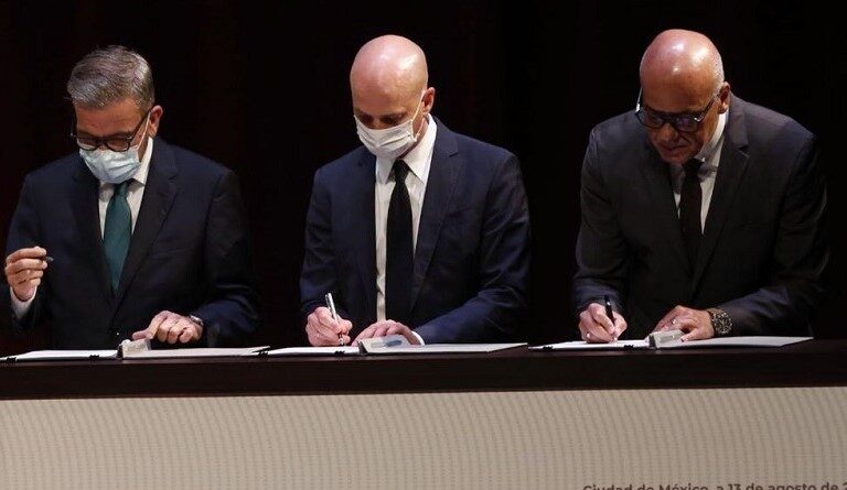 Jorge Rodríguez representing the Venezuelan government, Gerardo Blyde representing the opposition, and the representative from the Kingdom of Norway, all signing the document that officially launched the Mexico Talks in 2021. File photo.