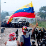 Iconic photo with two young Venezuelans holding a flag at one of the bridges that connects Colombia with Venezuela. File photo.