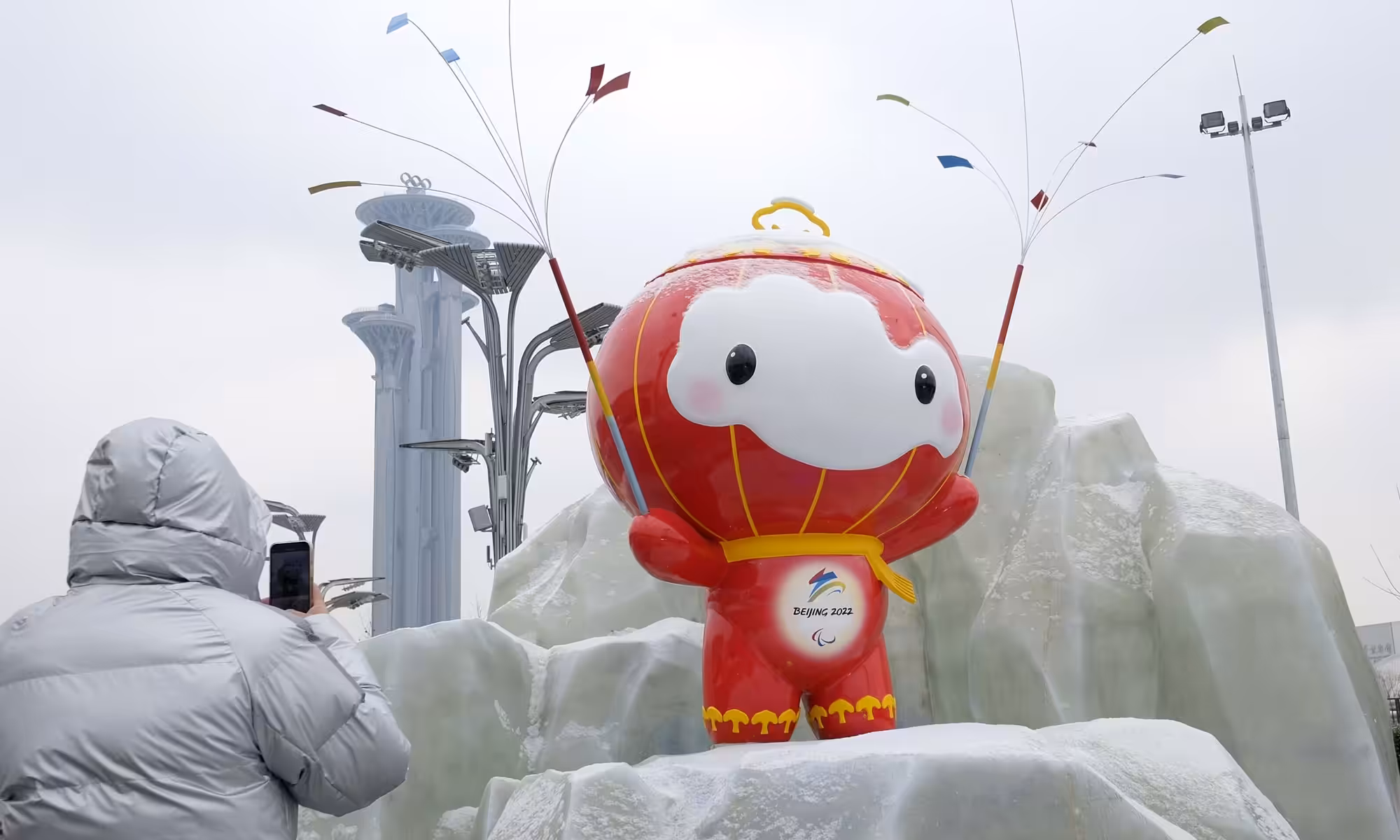 A Beijing resident takes a photo of the Beijing Winter Olympic Games mascot “Xue Rong Rong” sculpture on January 20, 2022, the solar term of Greater Cold, when the Chinese capital city experienced its first snowfall this year. Photo: cnsphoto