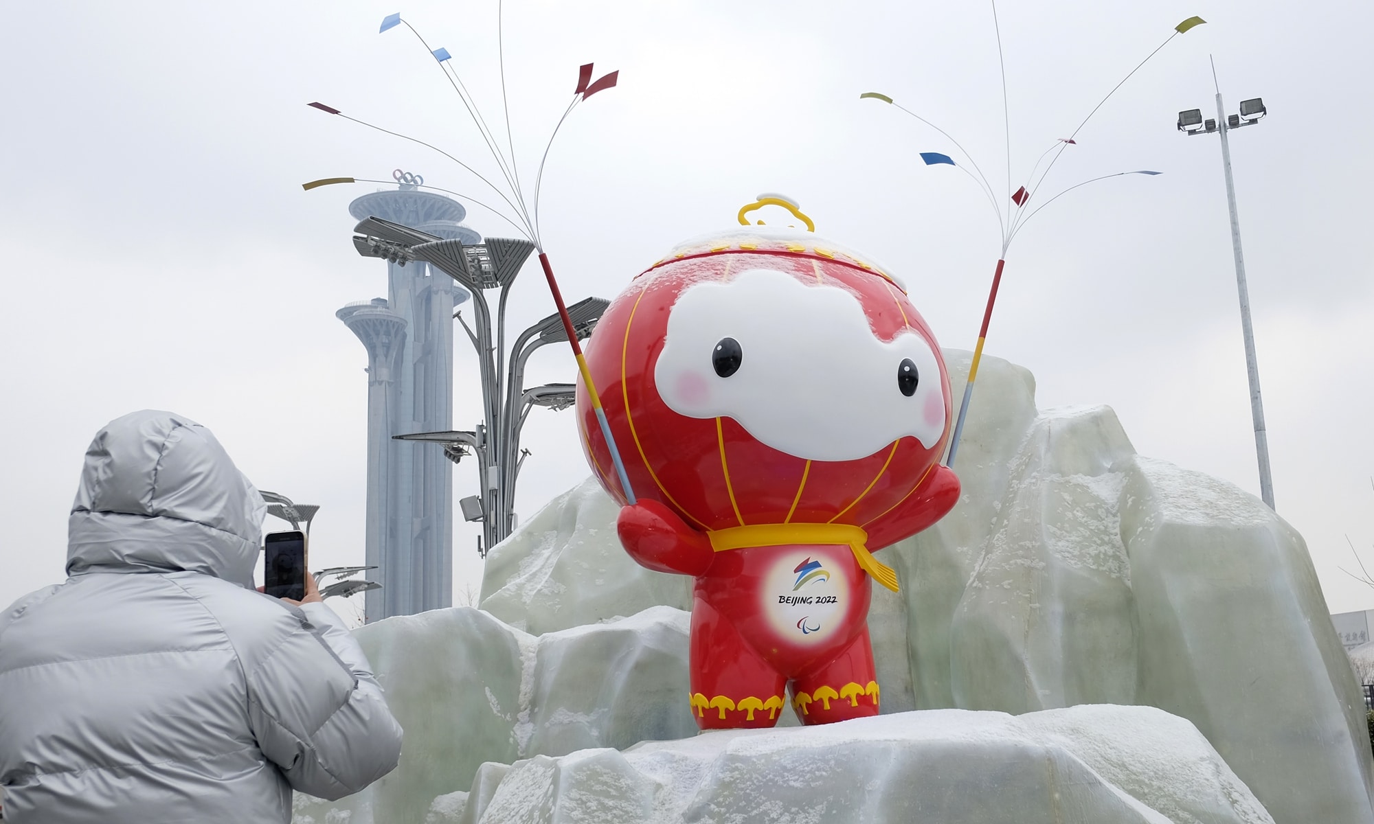 A Beijing resident takes a photo of the Beijing Winter Olympic Games mascot “Xue Rong Rong” sculpture on January 20, 2022, the solar term of Greater Cold, when the Chinese capital city experienced its first snowfall this year. Photo: cnsphoto