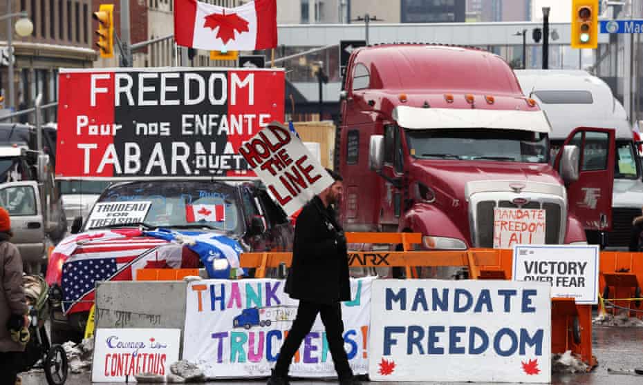 A protester walks in front of parked trucks in Ottawa, Canada. Photo: Dave Chan/AFP