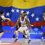 Venezuelan player Gregory Vargas facing two Paraguayan players with the Venezuelan flag in the background. Photo: FVB.