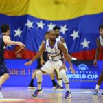 Venezuelan player Gregory Vargas facing two Paraguayan players with the Venezuelan flag in the background. Photo: FVB.
