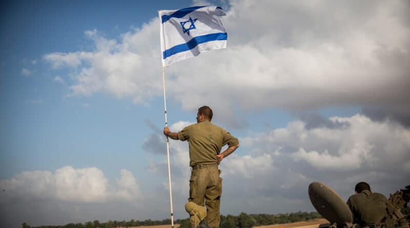 Israeli soldiers at the "buffer zone"—Gaza-Israel border—flying an Israeli flag. Photo: Andrew Burton/Getty Images
