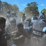 Residents face riot police during an attempted eviction at Tierras del Padre, a Lenca Indigenous community between the municipalities of Ojojona and San Buenaventura, Francisco Morazan department, Honduras, on February 9, 2022. Photo: Orlando Sierra/AFP via Getty Images.