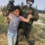 An Israeli soldier detains a Palestinian child in the Masafer Yatta area, March 10, 2021. Photo: B’tselem