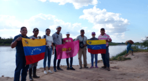 Featured image: A group of Venezuelans hoist two of their nation's flags. Photo: CRBZ