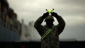 Soldier holding indicating yellow bars making the X sign. Photo: AP Photo / Francisco Seco.