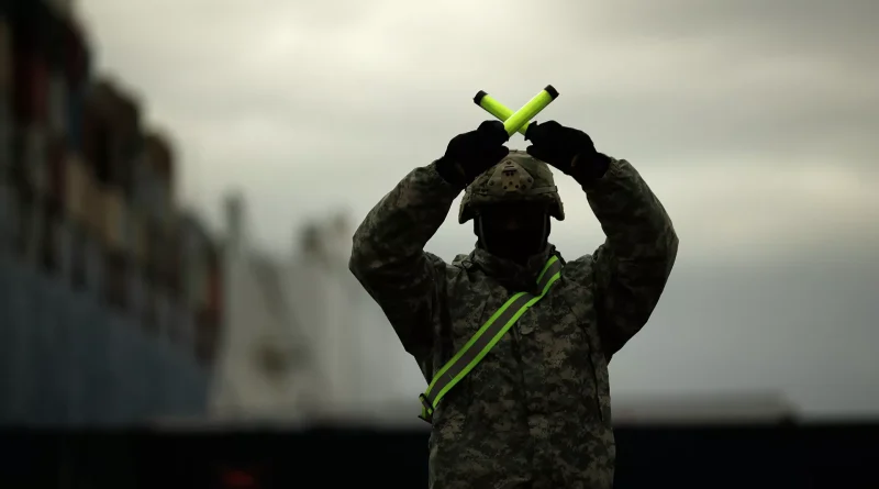 Soldier holding indicating yellow bars making the X sign. Photo: AP Photo / Francisco Seco.