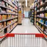 Shopping cart in a supermarket aisle empty of people and full of products. FIle photo.