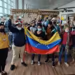 Venezuelan migrants returning from Ecuador posing with a Venezuelan flag. Photo: Twitter / #CancilleriaVE