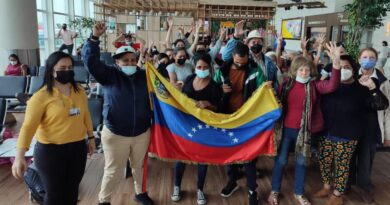 Venezuelan migrants returning from Ecuador posing with a Venezuelan flag. Photo: Twitter / #CancilleriaVE