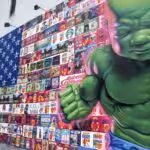 Graffiti depicting the US flag filled with logos of arms, real estate and other multinational corporations, and the figure of the hulk. Photo: Travis Wise
