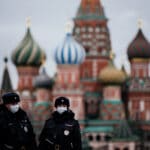Two police officers walking down the Red Square in Moscow with the Saint Basil Cathedral in the background. Photo: Getty Images.