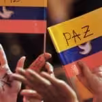 People waving Colombian flags with white doves and peace draw on them. Photo: Warscapes.