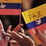 People waving Colombian flags with white doves and peace draw on them. Photo: Warscapes.