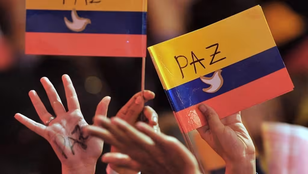 People waving Colombian flags with white doves and peace draw on them. Photo: Warscapes.