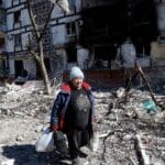 Featured image: A resident walks past a damaged building in Mariupol, March 28, 2022. Photo: Victor/Xinhua