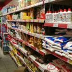 A single person in a grocery store aisle looking at prices and products. File photo.