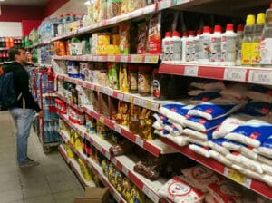A single person in a grocery store aisle looking at prices and products. File photo.