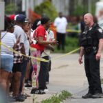 Featured image: An Officer speaks to distressed bystanders near the scene of the mass shooting in Buffalo, New York, Unite States on May 14, 2022, AP.