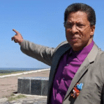 John Parker in the Lugansk People’s Republic. He’s pointing to explosions visible in the distance. SLL photo.