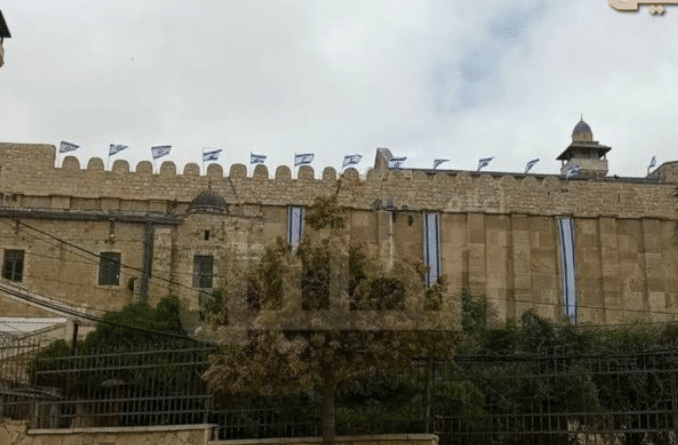 Featured image: Jewish settlers raised the Israeli flag atop the Ibrahimi Mosque in Hebron. Photo: via Palinfo.