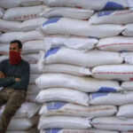 A man resting against a stack of wheat sacks. File photo.