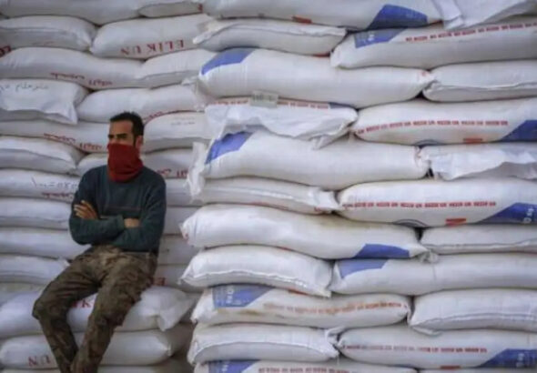 A man resting against a stack of wheat sacks. File photo.