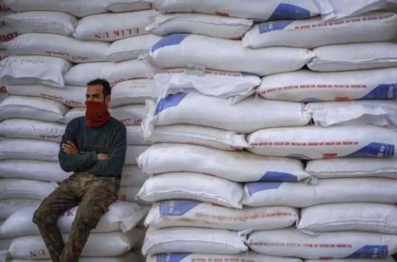 A man resting against a stack of wheat sacks. File photo.