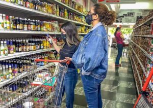 Three women in a supermarket alley in Venezuela doing groceries. File photo: EFE.