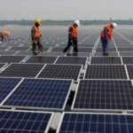 Workers inspect a solar panel installation. Photo: AP.