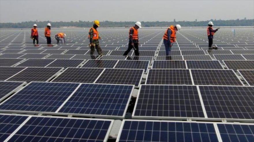 Workers inspect a solar panel installation. Photo: AP.