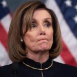Nancy Pelosi bites her lips with US flags in the background. File photo: AFP.