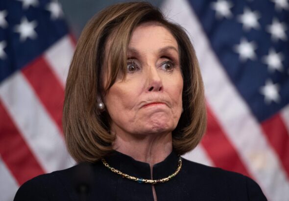 Nancy Pelosi bites her lips with US flags in the background. File photo: AFP.