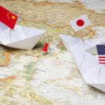 Map of Asia with three paper boats holding a China, a Japan and a US flag. File photo.