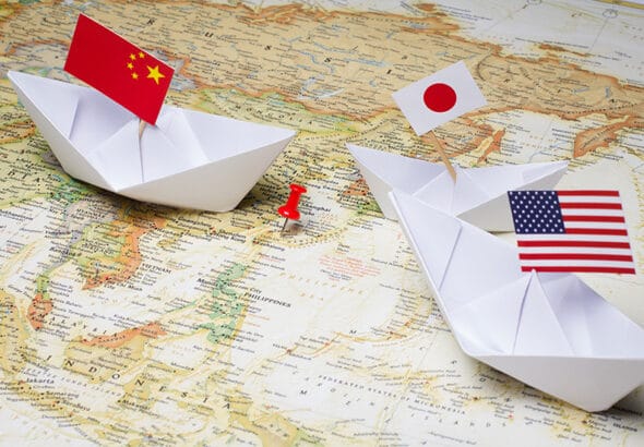 Map of Asia with three paper boats holding a China, a Japan and a US flag. File photo.