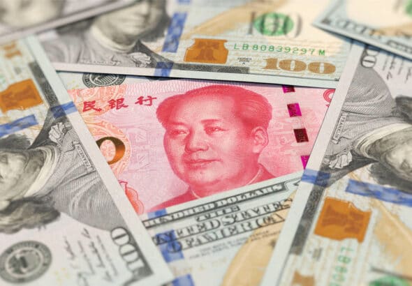 Chinese yuan among US dollar bills. File photo.