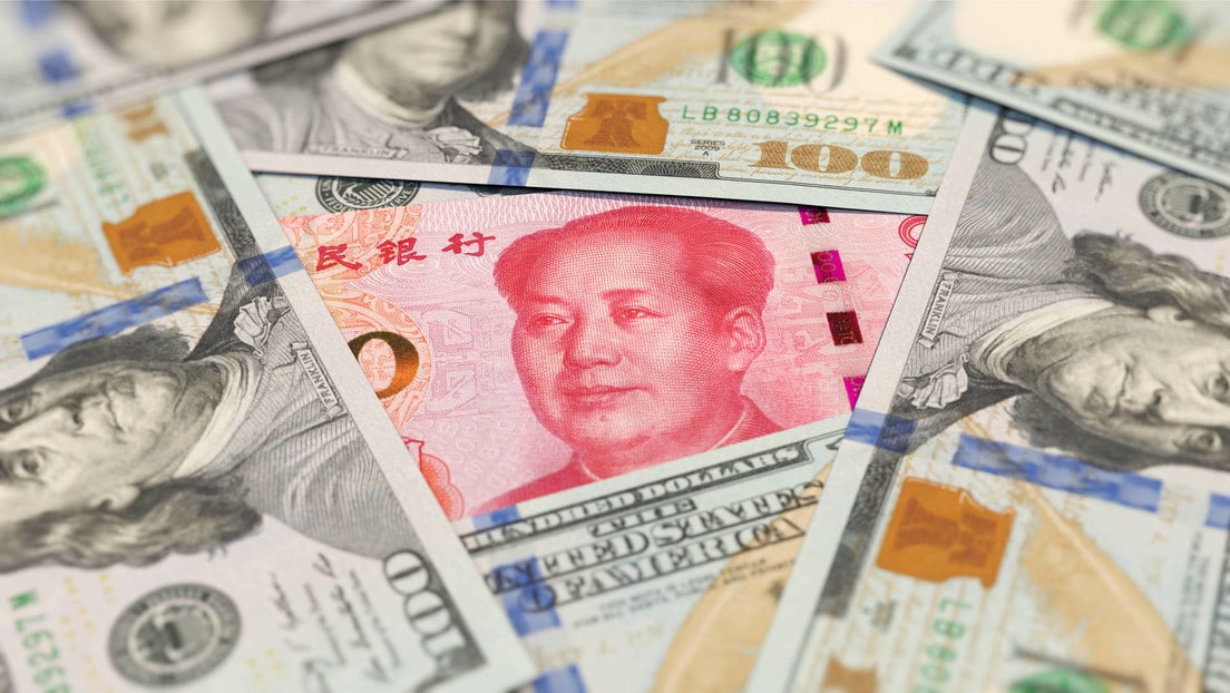 Chinese yuan among US dollar bills. File photo.
