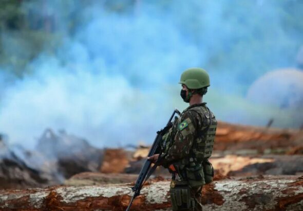 A member of the Brazilian army looks on as forest fires engulf a large part of the Amazon. Photo: Revista Opera.