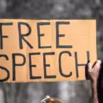 Person holding a placard that reads “Free speech.” File photo: Shutterstock.