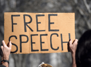 Person holding a placard that reads “Free speech.” File photo: Shutterstock.
