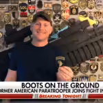 American neo-Nazi Paul Gray on Fox News in front of a wall featuring emblems of fascist militias like the Azov Battallion. Photo: Author